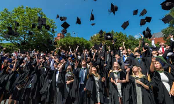 Graduates throw their mortarboards in the air