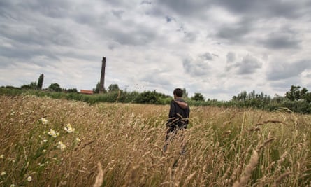 An Afghan migrant walks among the fields surrounding an abandoned brick factory on the outskirts of Subotica, Serbia. Migrants call the space the jungle.