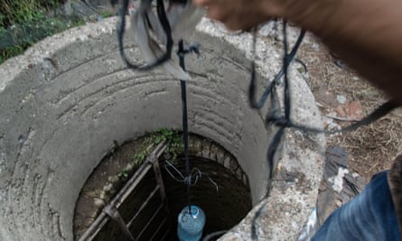 The migrants are forced to camp in the open air and hoist their water from an old well.