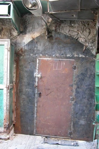 Israeli soldiers bricking up windows and welding shut doors that faced on to streets used by settlers.