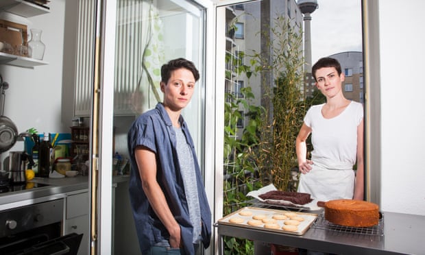Ruth and her partner with cakes she has baked in the kitchen of their flat in Berlin