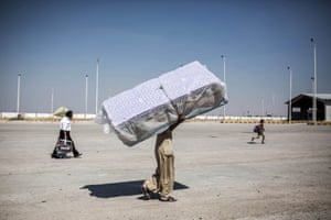 In the town of Tal Abyad, a Syrian refugee carries mattresses as he re-enters Syria from Turkey after Kurdish People's Protection Units took control of the area.