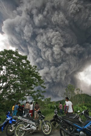 Villagers watch as mount Sinabung spews volcanic material into the air in North Sumatra, Indonesia. The volcano has continued to erupt almost daily since its alert status was raised earlier this month to the highest level. Thousands of villagers whose homes are in the danger zone have been evacuated.