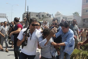 Police officers control the crowd while escorting a man suspected to be involved in a terrorist shooting at a beach resort in Sousse, Tunisia. 37 people were killed and 36 were wounded in the attack.