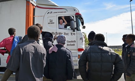 Migrants attempting to board lorries at Calais.