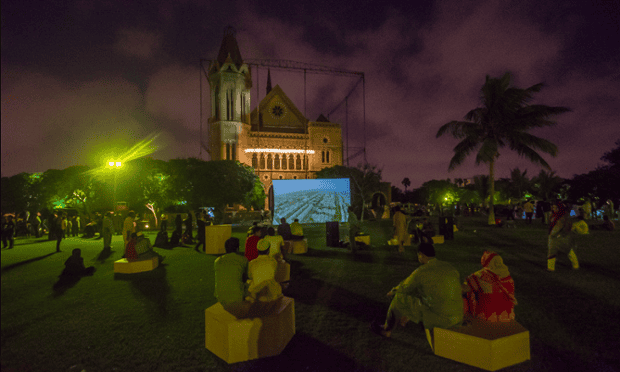 An audience watches a video installation outside Frere Hall in central Karachi, April 2015.
