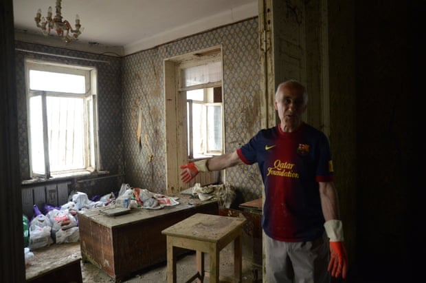 Murman Chanturashvili clears debris from his ground-floor flat on Svanidze Street.
