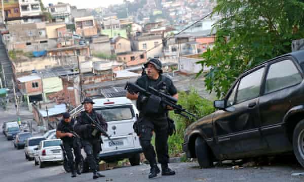 Officers from the CORE police special forces patrol during an operation to search for fugitives in a favela in Rio de Janeiro, Brazil. 