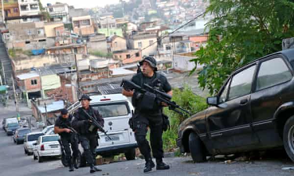 Officers from the CORE police special forces patrol during an operation to search for fugitives in a favela in Rio de Janeiro, Brazil.