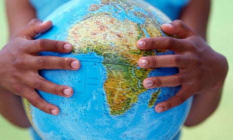 a girl holds a globe in her hands.