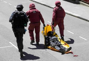 A man playing the role of a wounded victim is dragged away by members of the emergency services