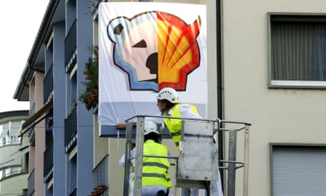 Members of Greenpeace put a banner over the company logo at a Shell gas station during a protest in Zurich this week.