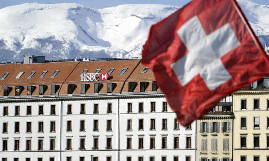 A Swiss flag flies above a HSBC logo is seen on HSBC offices in Geneva, Switzerland.
