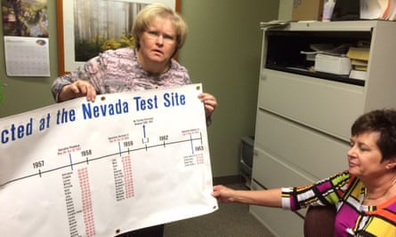 Rebecca Barlow, left, and Carolyn Rasmussen, right, at the Radiation Exposure Screening and Education Program clinic in St George. They display a sheet detailing above ground nuclear tests in Nevada.