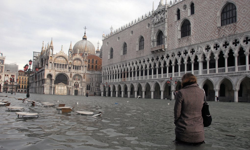 A woman walks through Piazza San Marco during a flood. Waters regularly reach above 130cm in the winter months.