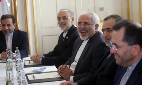 Iranian foreign minister Javad Zarif laughs during a meeting with U.S. Secretary of State John Kerry at nuclear talks in Vienna on Tuesday. Deputy minister Majid Ravanchi is nearest the camera.   (Carlos Barria/Pool via AP)
