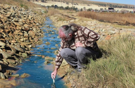 David Van Wyk, research director of charity Bench Marks, tests water in a run-off canal in Soweto.