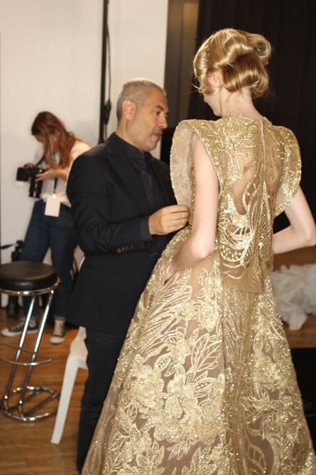 Elie Saab speaks to a model backstage wearing one of his latest Game of Thrones-style creations.