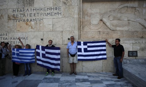 Anti-austerity protesters hold Greek flags during a rally against the government's agreement with its creditors.