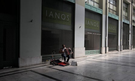 A street musician plays the accordion in an arcade in central Athens where shops are closed due to recession.