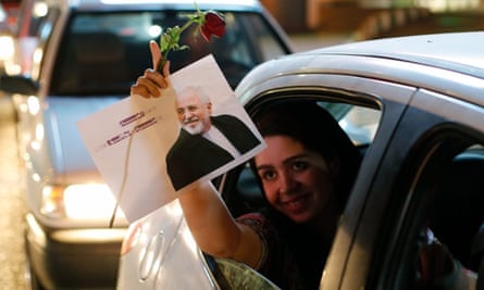 An Iranian woman holds a flower and a poster of Iranian foreign minister Mohammad Javad Zarif as she celebrates in the street of Tehran after nuclear talks between Iran and World powers ended in Vienna.