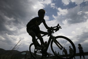 A rider is silhouetted against the sky as he speeds downhill 