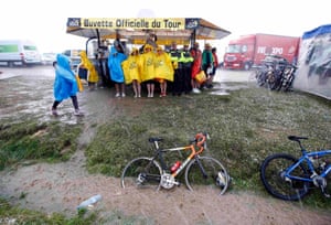 Spectators at the finish line take shelter from heavy rain and hail