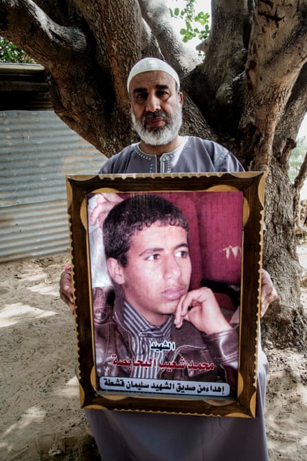 Shuaib Hussein Behabsa with a poster of his 17-year-old son, Mohammad, a pupil at Doha school in Rafah, who was killed during an air and artillery strike on his home.