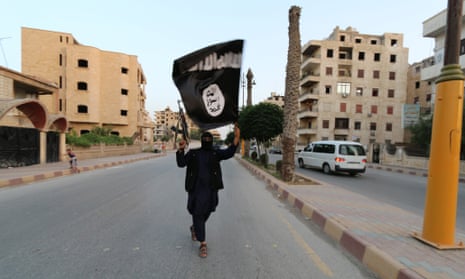A fighter waves an ISIS or ISIL flag in Raqqa, Syria.