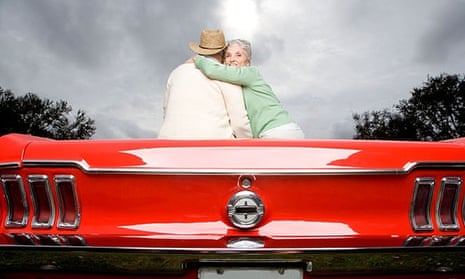 older couple sitting on sports car