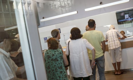 People stand in line inside a bank in Athens today.