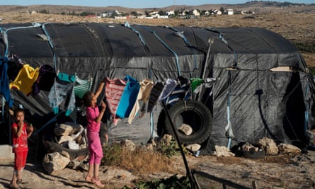One of the temporary structures that is home to the villagers of Khirbet Susiya with the Israeli settlement of Susiya in the background. Banned from building by the Israeli authorities, the 80 or so shelters provide homes for several hundred Palestinians in the south of the West Bank. Unlike the Israeli settlement Khirbet Susiya is not connected to running water.