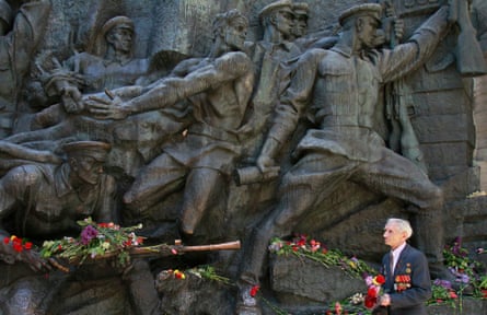 A Ukrainian world war two veteran passes by a war memorial in Kiev.