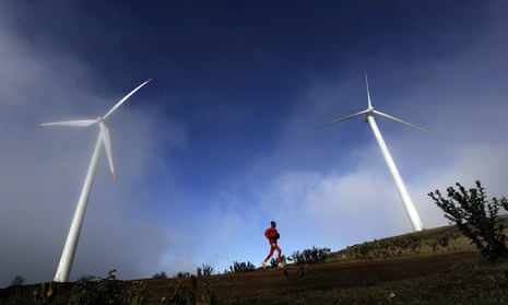 A man running past wind turbines in the early morning mist in the Ngong hills, some 25 kms south-west of Nairobi.