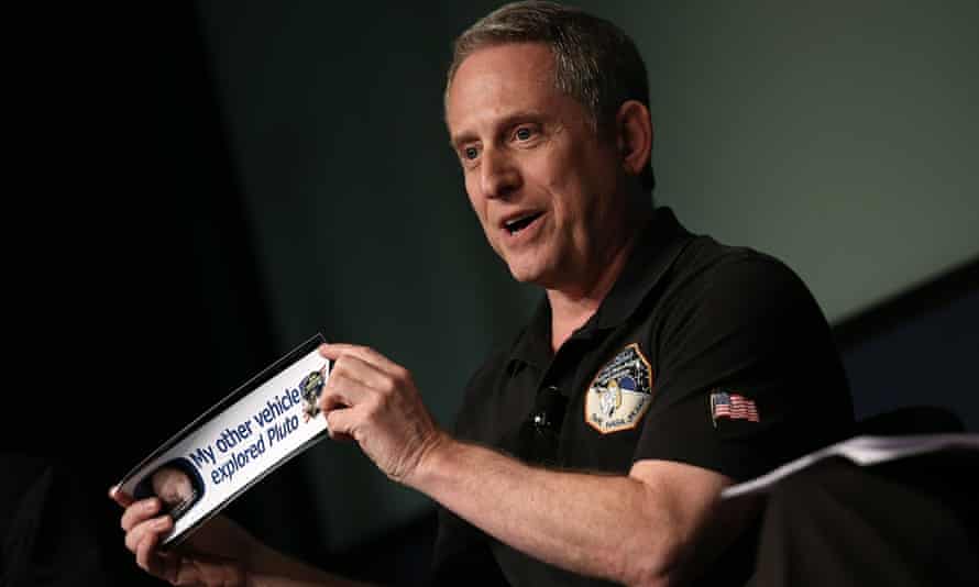 Alan Stern, principal investigator of NASA's New Horizons mission team, holds up a bumper sticker  at Nasa headquarters on Friday.