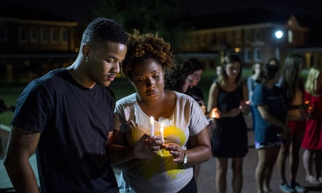 Students pray during a candlelight vigil for the Grand 16 theater shooting victims at the University of Louisiana at Lafayette.