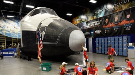 Campers do an activity in front of a mockup space shuttle.
