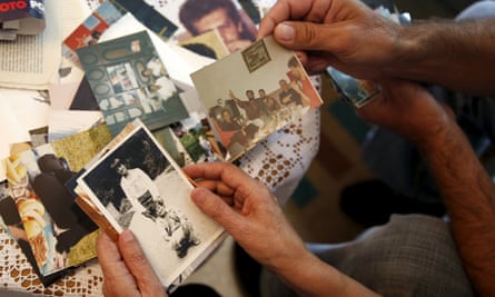 Hajra Catic and Edmin Jakubovic look at pictures of Hajra's son at her home in Srebrenica.