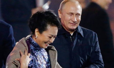 Vladimir Putin puts a shawl on Peng Liyuan, the wife of the Chinese president, Xi Jinping, at a firework display last year.