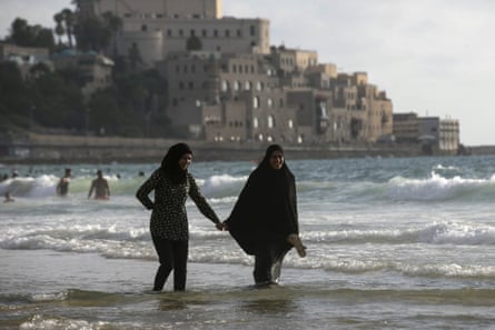Muslim women walk along beach in Tel Aviv.