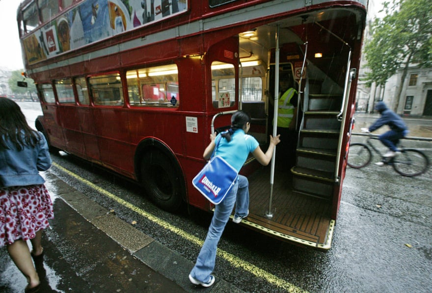 A passenger 'hopping on' a old-style Routemaster bus.