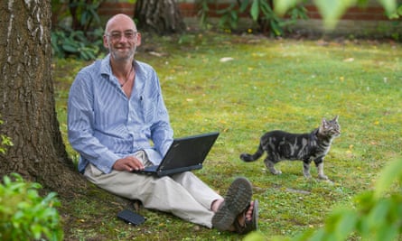 Ben Gunn sitting in garden with laptop and cat