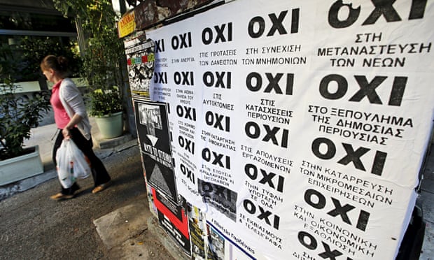 A woman in Athens walks past referendum campaign posters reading "No" in Greek.