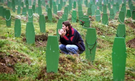 A Bosnian Muslim man prays between graves of victims of the 1995 Srebrenica massacre after the morning prayers on the first day of Eid al-Fitr November 3, 2005.
