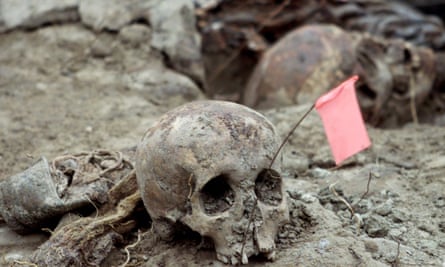 Bosnian forensic experts uncover and catalogue bodily remains found in a mass grave in the eastern village of Kamenica, near the town of Zvornik, close to the border with Serbia on 25 July 2002.