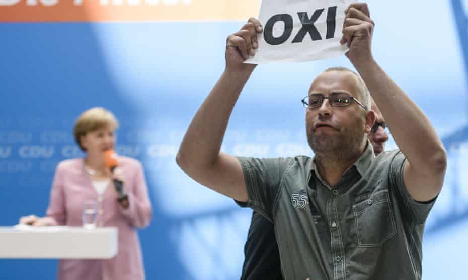A protester interrupts Angela Merkel as she addresses and audience of her Christian Democratic Union party members on Saturday.