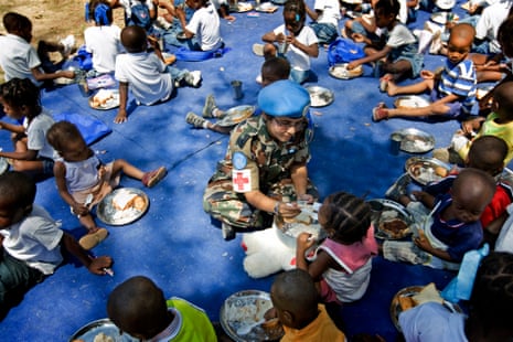 A UN soldier in Haiti distributes food to children in Port-au-Prince. 