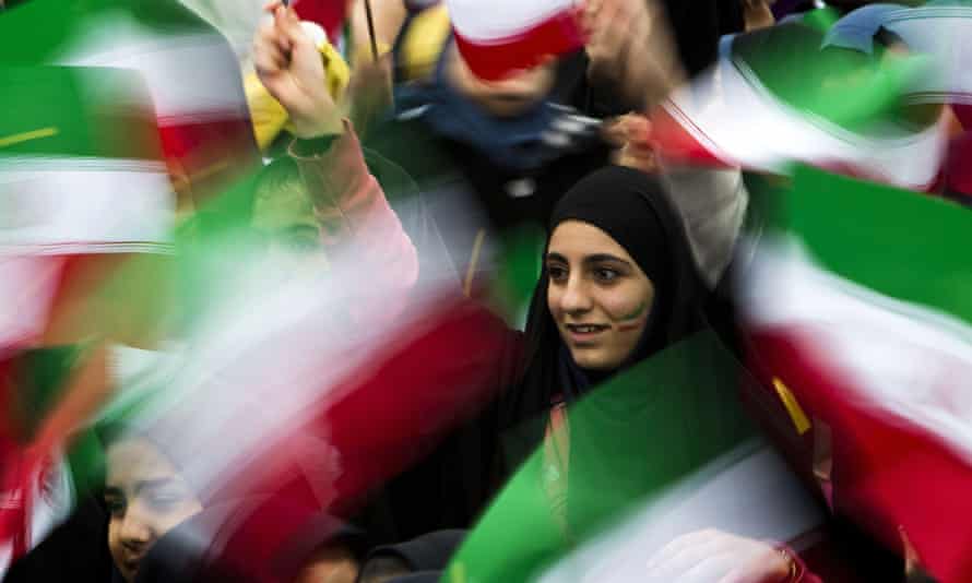Iranian schoolgirls wave their national flag