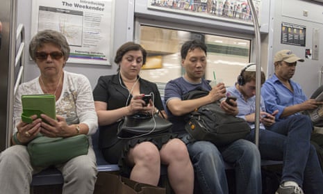 New York subway riders immersed in their electronic devices.