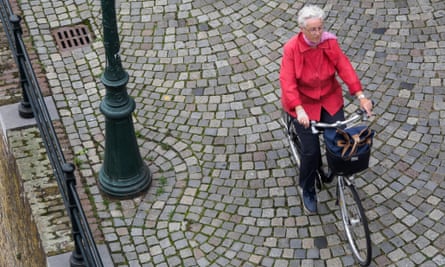 An old lady riding a bicycle.